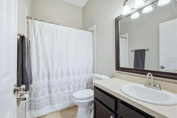 a bathroom with a sink a toilet and shower curtain