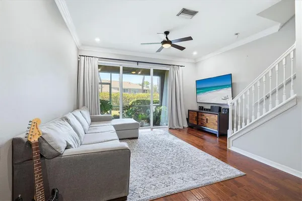 a living room with furniture flat screen tv and a large window