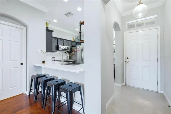 a kitchen with stainless steel appliances a dining table chairs and a refrigerator