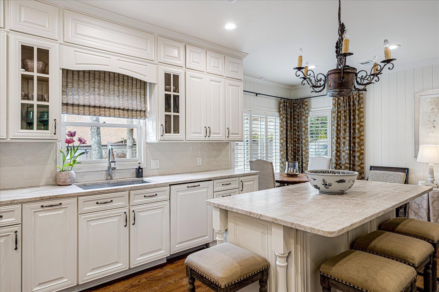 485 River Ridge Cove Memphis, TN 38120 - Photo 15 of 33 Kitchen featuring a breakfast bar area, dark wood-style flooring, suspended lighting, crown molding, and glass fronted cabinets