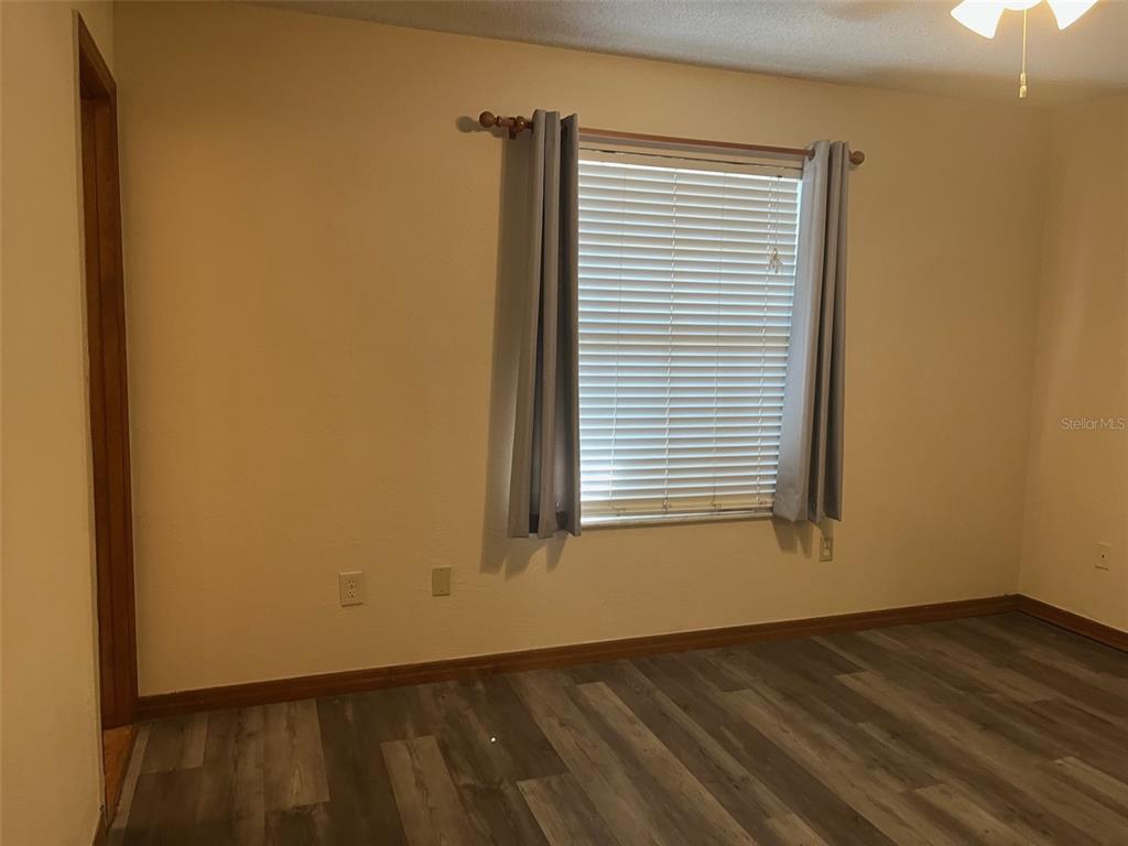 175 Conrad Street Port Orange, FL 32127 - Photo 7 of 13 a view of an empty room with wooden floor and a window