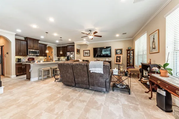 a kitchen with stainless steel appliances granite countertop a stove top oven a sink dishwasher a dining table and chairs with wooden floor