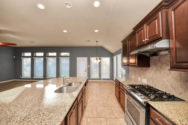 a kitchen with stainless steel appliances granite countertop a stove and a sink