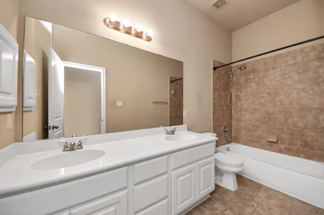 a bathroom with a granite countertop sink a mirror and a bathtub