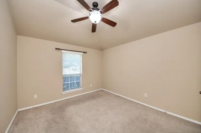 an empty room with closet and a chandelier fan