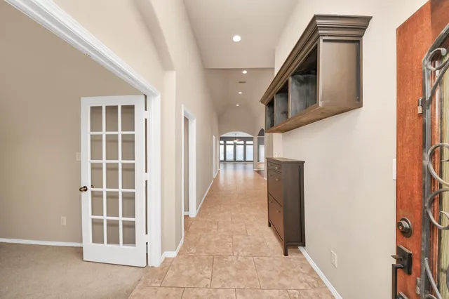 an empty room with windows closet and chandelier fan