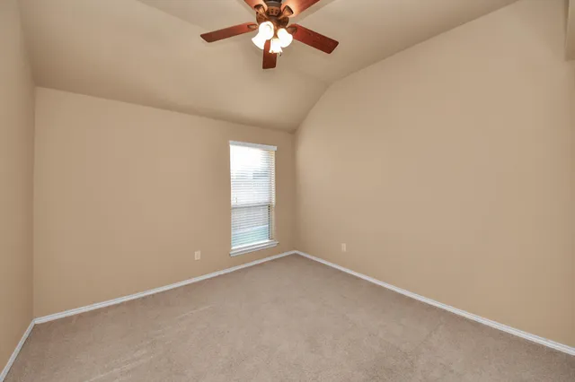 a view of a room with a ceiling fan and a window
