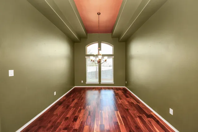 a view of a room with wooden floor and chandelier
