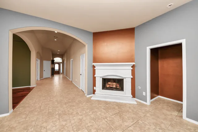 a view of an empty room with a fireplace and a window