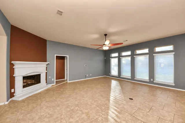 a view of an empty room with a fireplace and a window