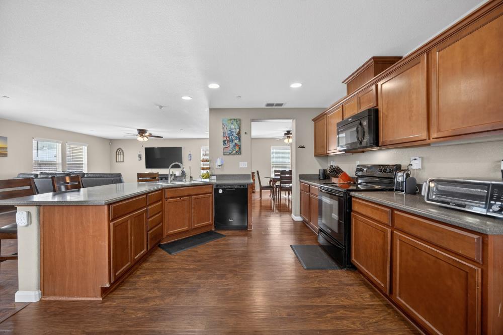 7467 Garden Ridge Way Sacramento, CA 95829 - Photo 12 of 54 a large kitchen with stainless steel appliances and a large counter top