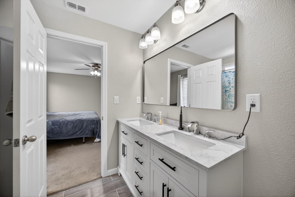 7467 Garden Ridge Way Sacramento, CA 95829 - Photo 26 of 54 a en suite bathroom with a sink double vanity and a mirror