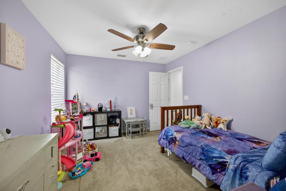 7467 Garden Ridge Way Sacramento, CA 95829 - Photo 29 of 54 a bed room with a bed and a chandelier