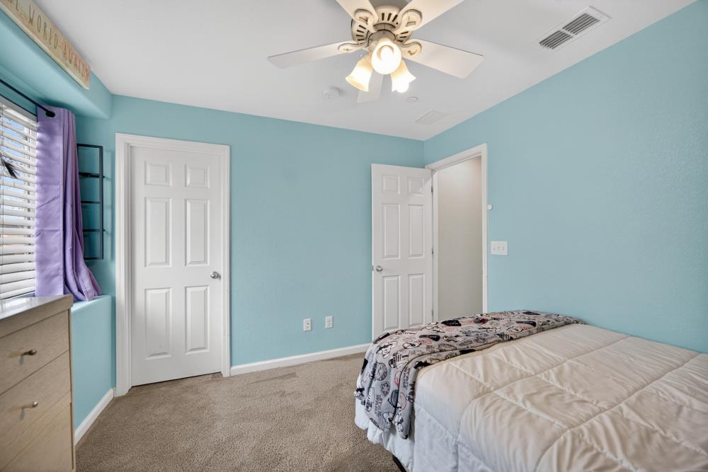 7467 Garden Ridge Way Sacramento, CA 95829 - Photo 32 of 54 a bedroom with a large bed and a chandelier