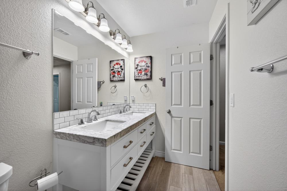 7467 Garden Ridge Way Sacramento, CA 95829 - Photo 36 of 54 a spacious bathroom with a double vanity sink and a mirror