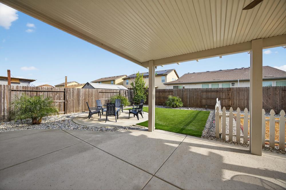 7467 Garden Ridge Way Sacramento, CA 95829 - Photo 41 of 54 a view of a patio with a table and chairs under an umbrella