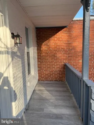 a view of a balcony with wooden floor and a floor to ceiling window