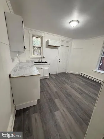 a room with a sink dishwasher stove and cabinets
