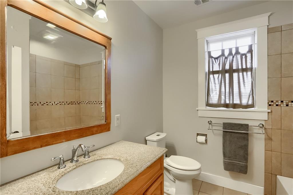 801 Main Street Coraopolis, PA 15108 - Photo 16 of 25 a bathroom with a granite countertop toilet a sink and a mirror