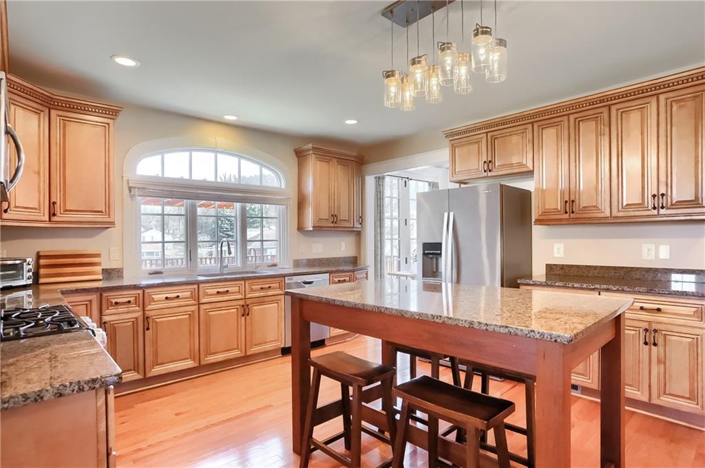801 Main Street Coraopolis, PA 15108 - Photo 6 of 25 a kitchen with stainless steel appliances granite countertop a stove top oven a refrigerator a sink and dining table with wooden floor