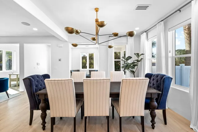 a view of a a dining room with furniture window and wooden floor