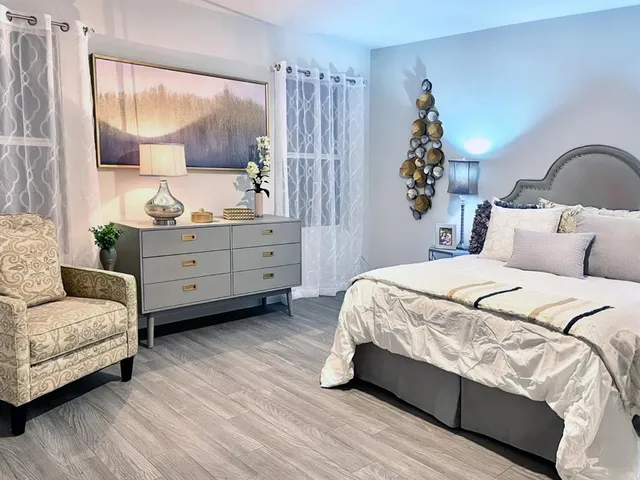 a spacious bedroom with a bed and a dresser