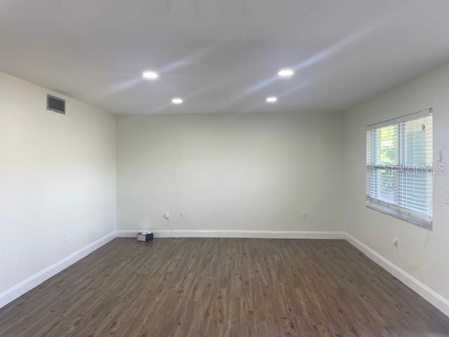 4800 Rilma Avenue, Unit 141 Sarasota, FL 34234 - Photo 7 of 19 an empty room with wooden floor and windows