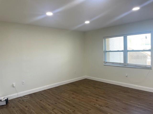 4800 Rilma Avenue, Unit 141 Sarasota, FL 34234 - Photo 8 of 19 wooden floor in an empty room with a window