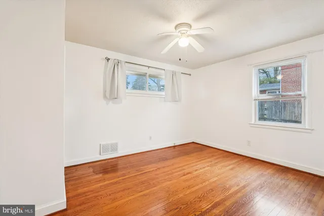 a view of empty room with wooden floor