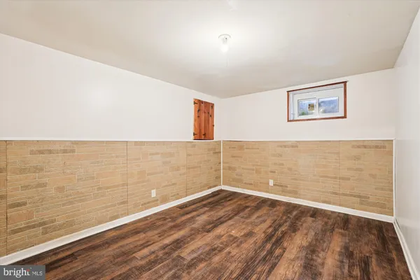 a view of a room with wooden floor and brick walls