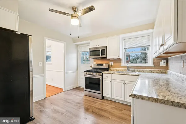 a kitchen with stainless steel appliances granite countertop a refrigerator stove microwave and sink