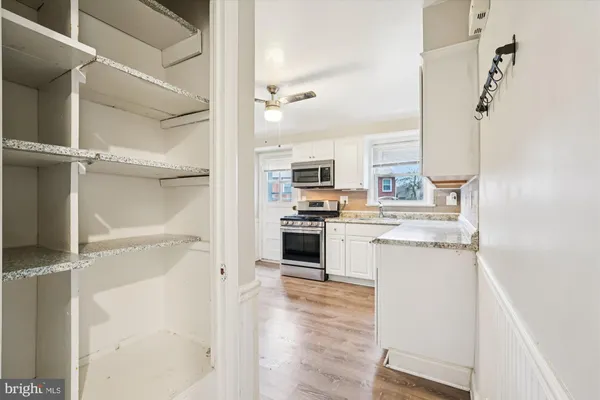 a kitchen with a refrigerator and white cabinets