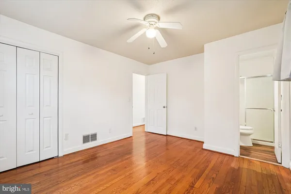 a view of a room with wooden floor and a ceiling fan