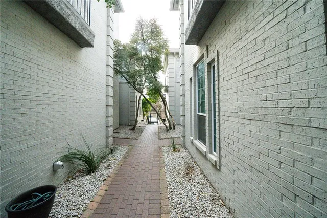 a pathway between a brick wall