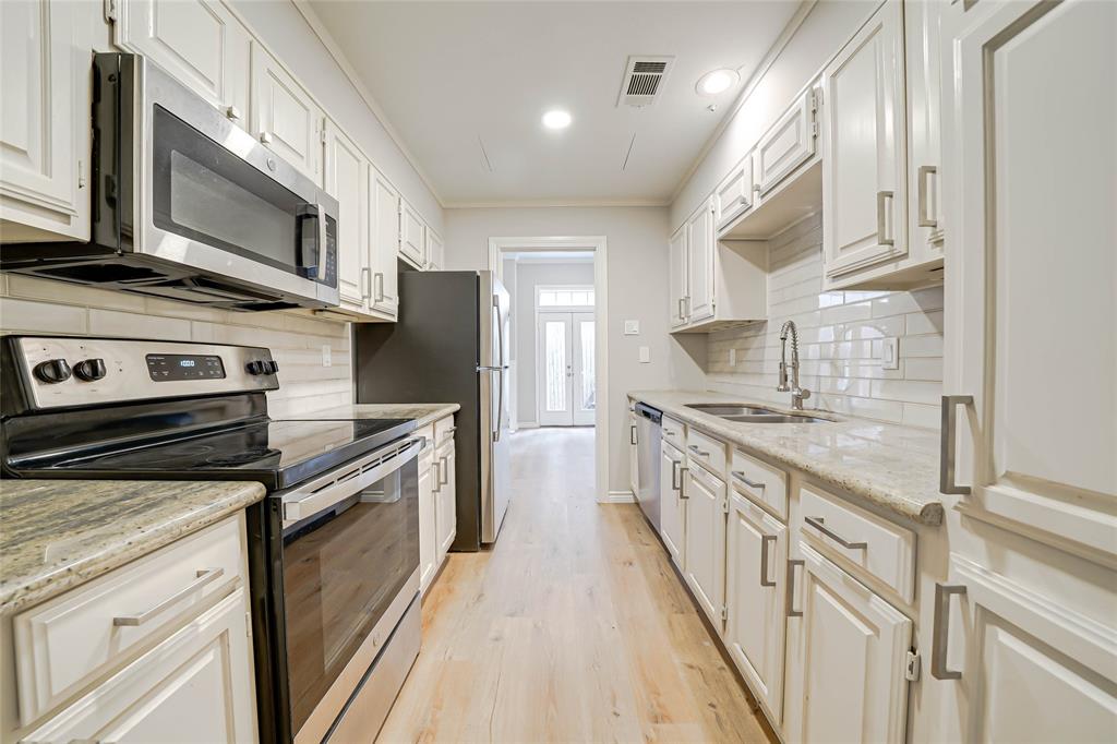 3605 Brown Street, Unit B108 Dallas, TX 75219 - Photo 4 of 18 a kitchen with stainless steel appliances granite countertop a stove a sink and a refrigerator