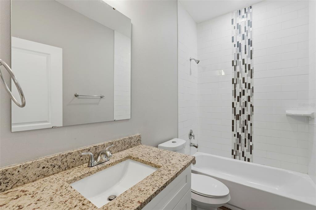314 Colonade Court, Unit B Kissimmee, FL 34758 - Photo 19 of 24 a bathroom with a granite countertop sink a toilet and shower