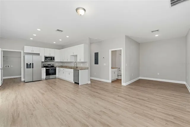 a view of kitchen with wooden floor and electronic appliances