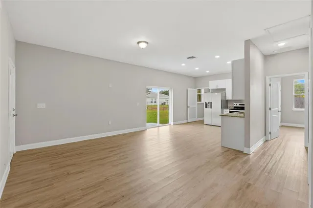 a view of a kitchen with wooden floor and a window