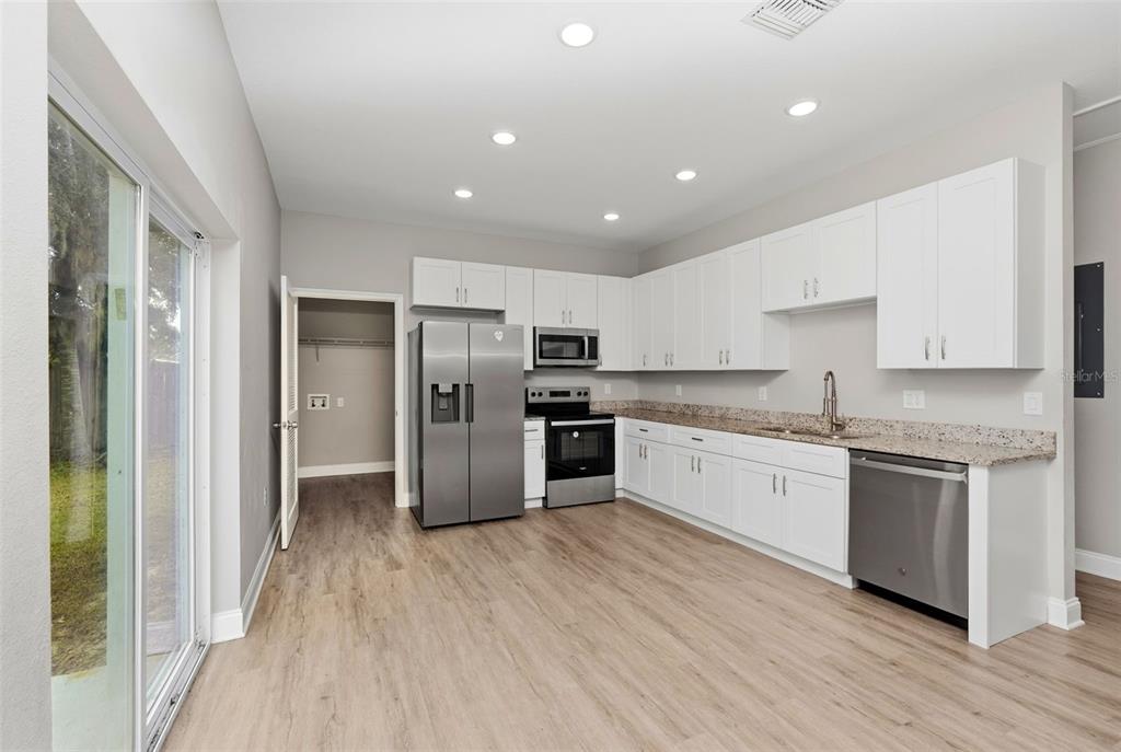 314 Colonade Court, Unit B Kissimmee, FL 34758 - Photo 10 of 24 a large kitchen with granite countertop a large counter top a sink stainless steel appliances and cabinets