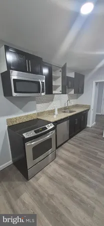 a kitchen with stainless steel appliances granite countertop a sink and a stove