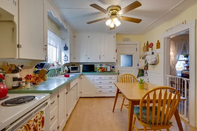 a kitchen with stainless steel appliances kitchen island granite countertop a stove a sink a dining table and chairs with wooden floor