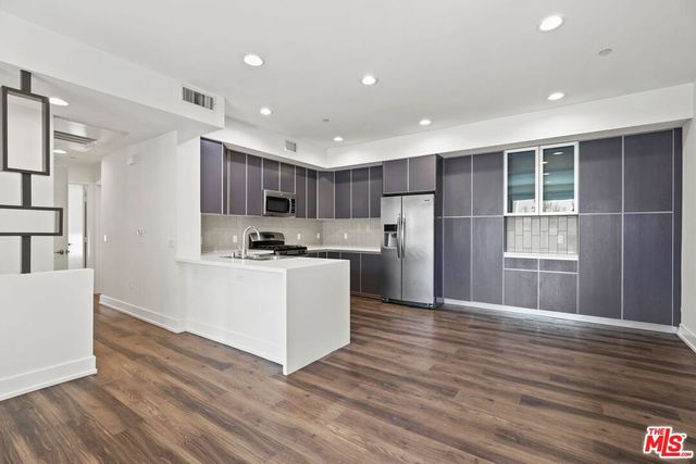 a kitchen with stainless steel appliances granite countertop a refrigerator sink and cabinets