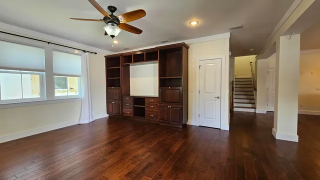a view of a livingroom with wooden floor and a ceiling fan