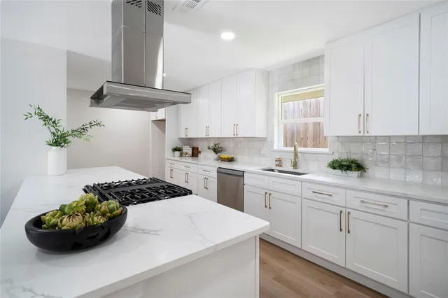 a kitchen with white cabinets and appliances