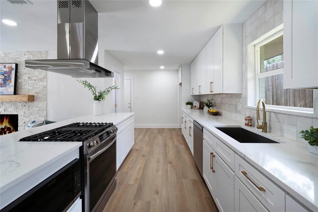10416 Church Road Dallas, TX 75238 - Photo 14 of 36 a kitchen with granite countertop stainless steel appliances sink stove and cabinets