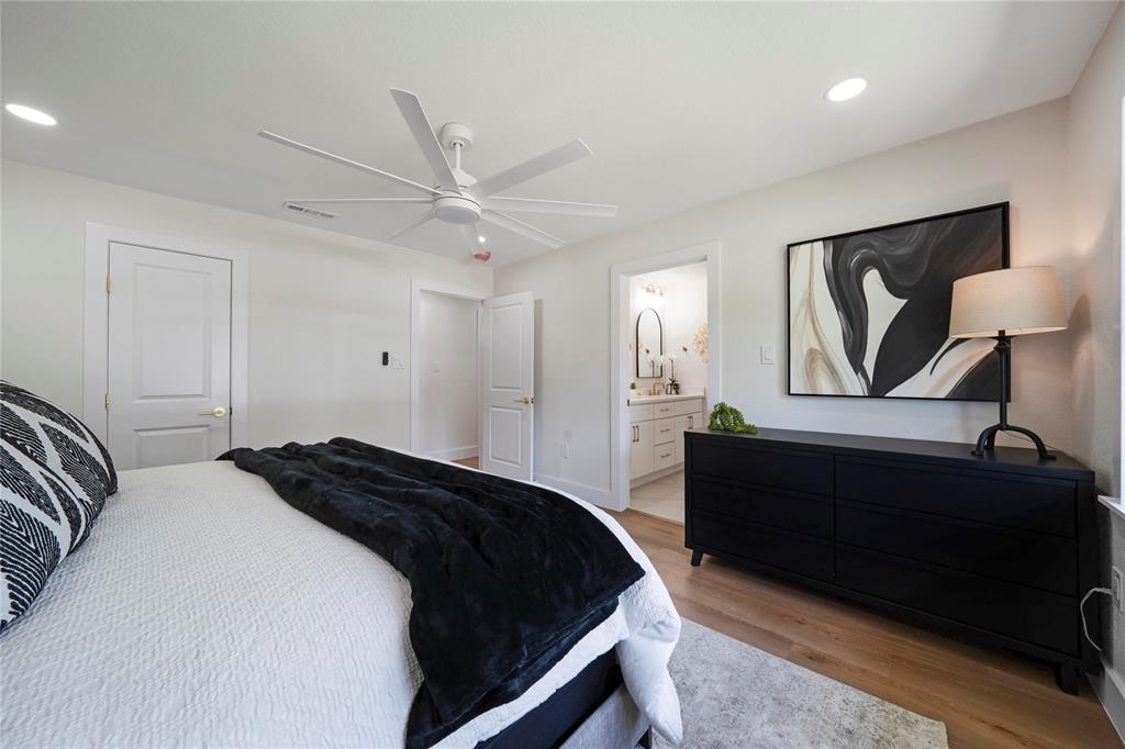 10416 Church Road Dallas, TX 75238 - Photo 25 of 36 a bedroom with a bed and a chandelier