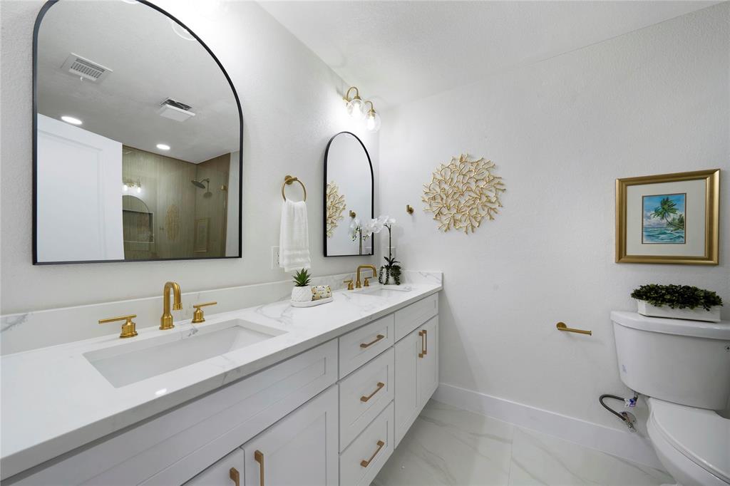 10416 Church Road Dallas, TX 75238 - Photo 26 of 36 a bathroom with a double vanity sink mirror and toilet