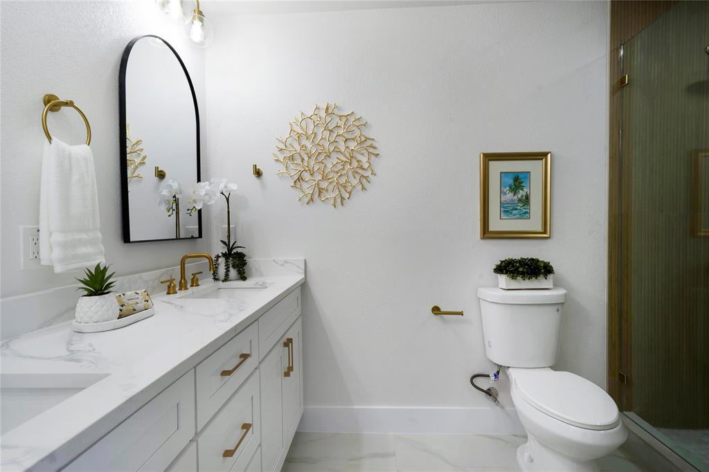 10416 Church Road Dallas, TX 75238 - Photo 27 of 36 a bathroom with a granite countertop toilet sink and mirror