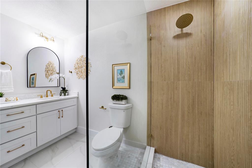 10416 Church Road Dallas, TX 75238 - Photo 30 of 36 a bathroom with a toilet sink and mirror