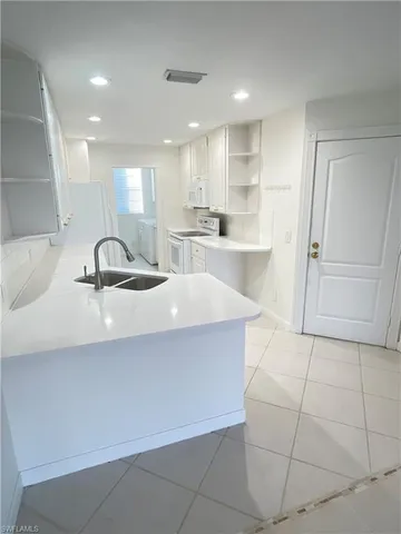 a kitchen with a sink a refrigerator and cabinets